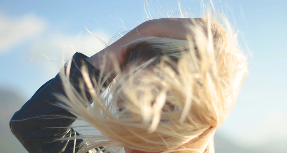 Frau mit blonden Haaren im Wind